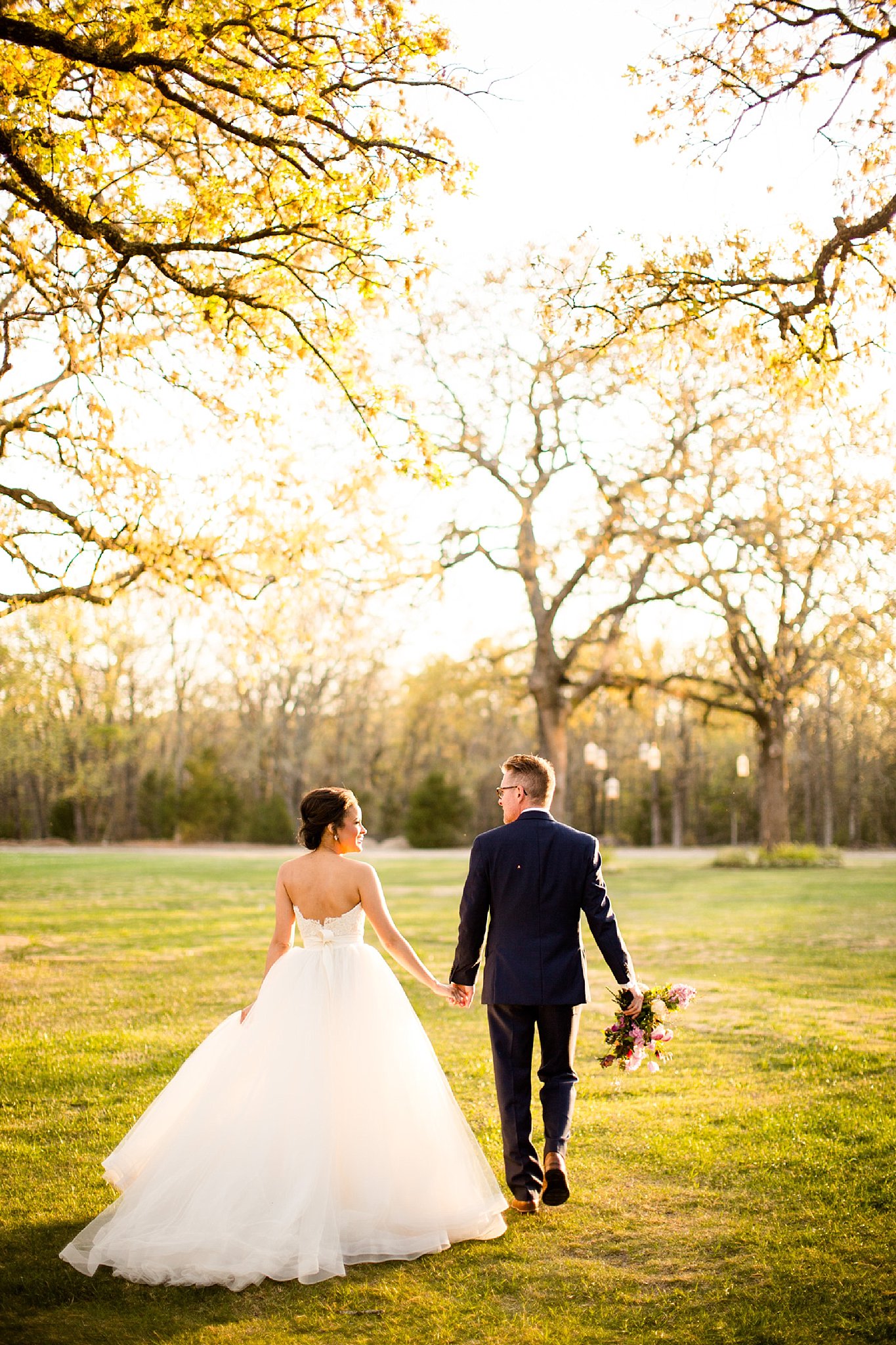 Bride and groom walking into the sunset at White Sparrow Barn