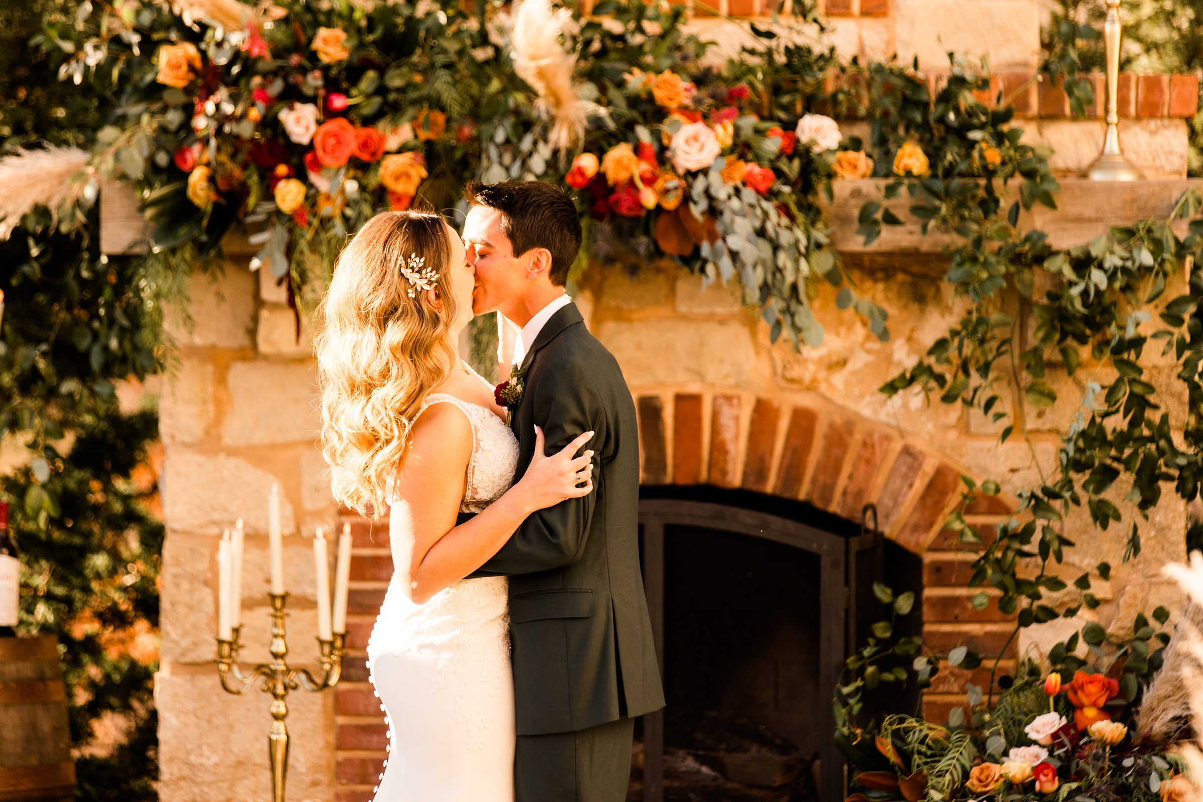 bride and groom kissing at their wedding with a floral background - St. Louis Wedding Venues